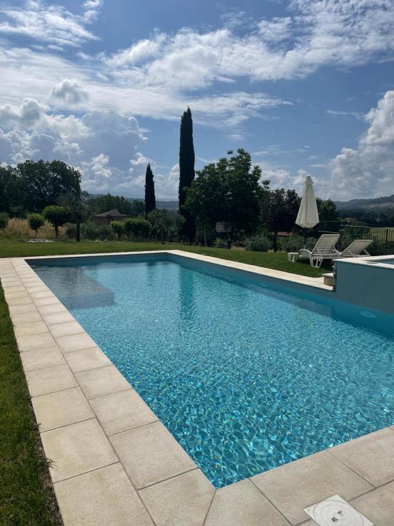 einen Pool mit blauem Wasser im Hof in der Unterkunft Casale Il Fontanello in Todi