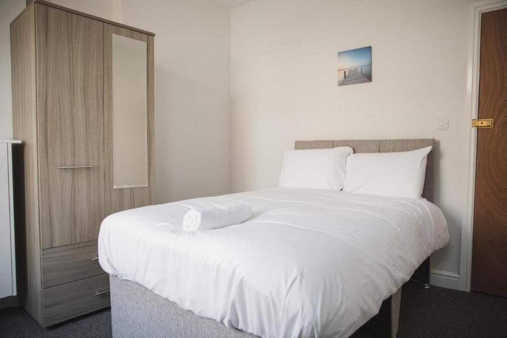 sypialnia z dużym łóżkiem z białą pościelą i poduszkami w obiekcie Luxury City Rooms in Leicester w mieście Leicester