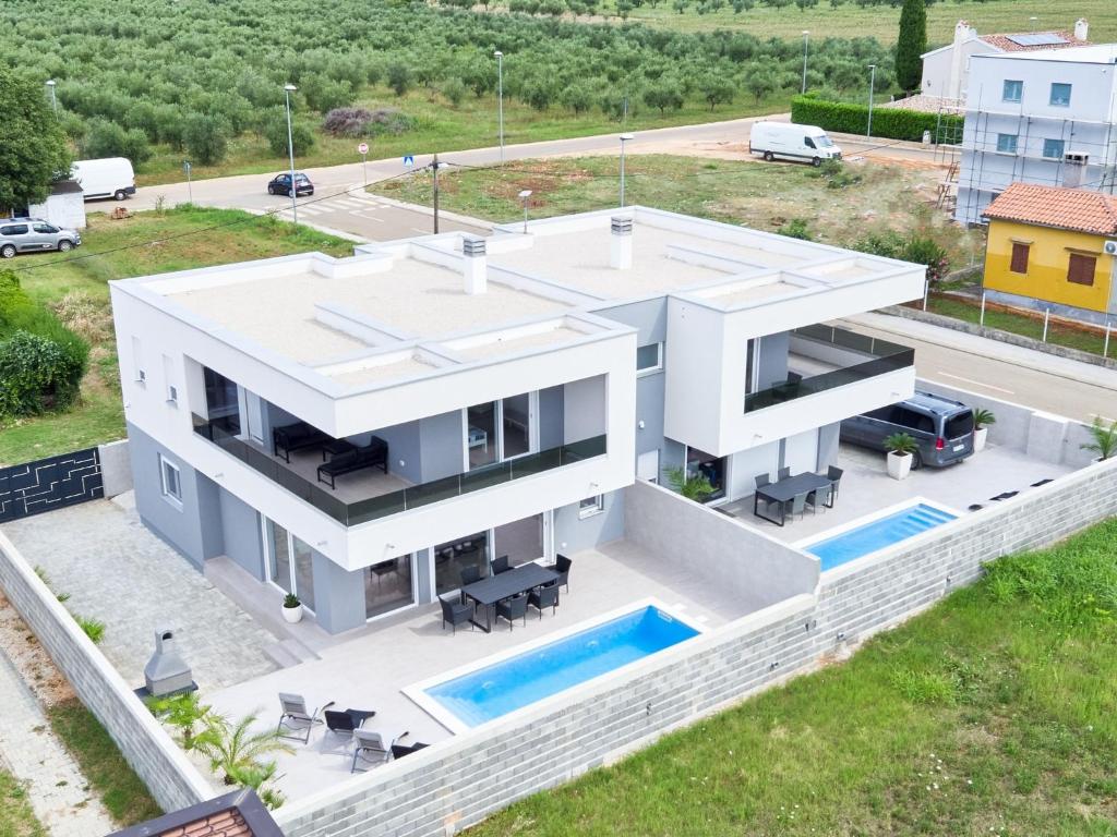 an aerial view of a white house with a swimming pool at Villa Kana in Umag