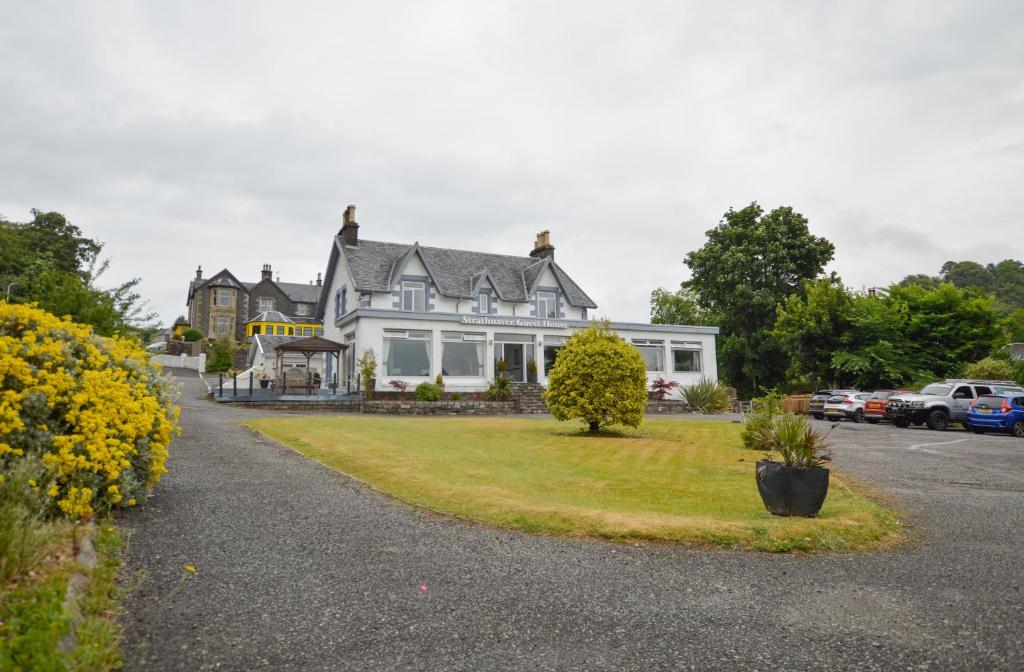a large white house with a lawn in front of it at Strathnaver in Oban