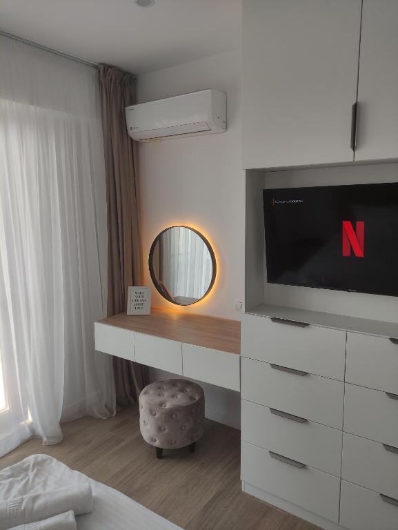 a hotel room with a tv and a mirror at Aparthotel Black Sea in Constanţa