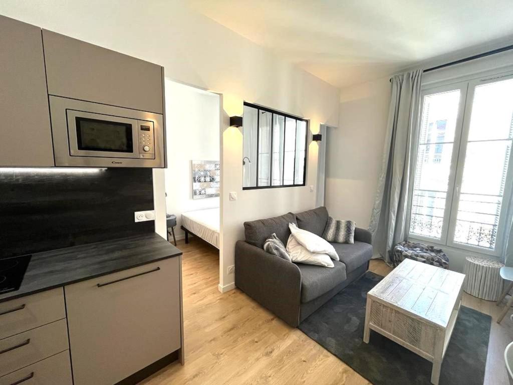 un salon avec un canapé et une télévision dans l'établissement Hypercentre lamartine 404, à Nice