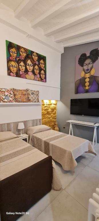 阿格里真托的住宿－Arte in piazza Agrigento centro，客房设有三张床和一台平面电视。