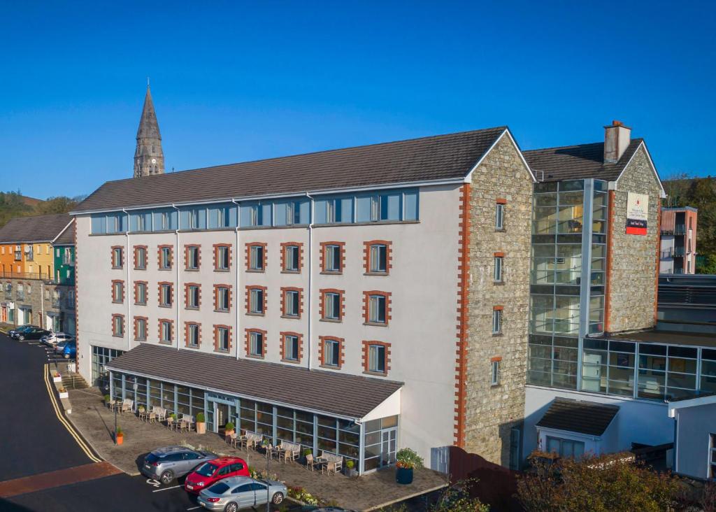 ein großes Gebäude mit davor geparkt in der Unterkunft Clifden Station House Hotel in Clifden