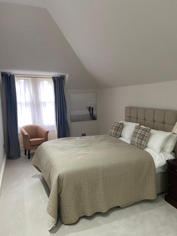 a bedroom with a large bed and a chair at Merchiston Residence in Edinburgh