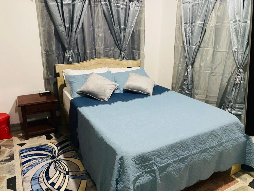 - un lit avec des draps et des oreillers bleus dans une chambre dans l'établissement HOTEL IMPERIAL LA QUINTA, à Aguachica