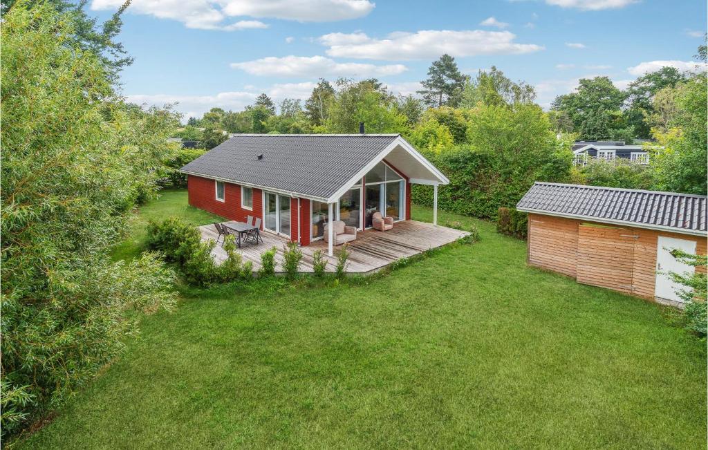 ein kleines rotes Haus mit einer Terrasse im Hof in der Unterkunft Gorgeous Home In Jgerspris With Kitchen in Jægerspris