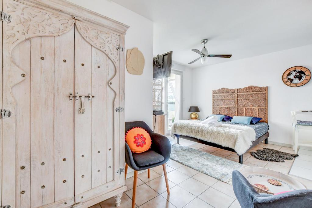 Un dormitorio con un gran armario de madera y una cama en L Oasis studio proche hôpital et aéroport Piscine Parking &Netflix, en Toulouse