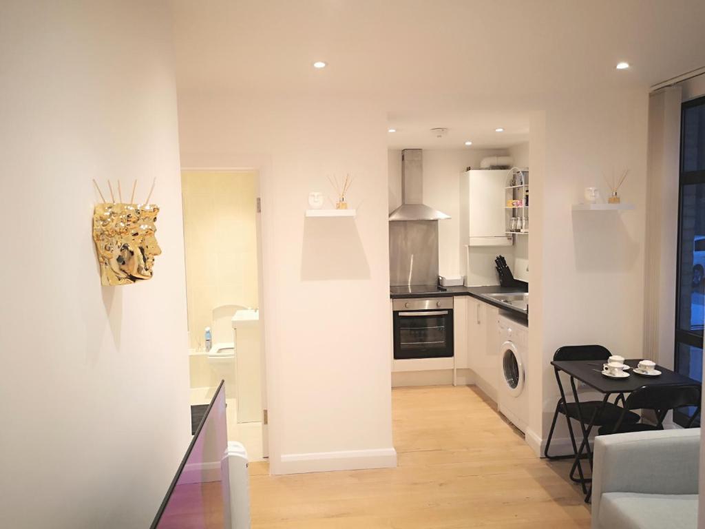 a kitchen and living room with a table and a stove at Clifton court hemel in Hemel Hempstead