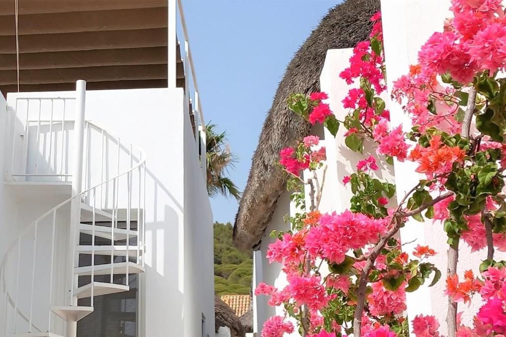 a white building with pink flowers on it at Mandala Bungalows - Adults Only in Los Caños de Meca