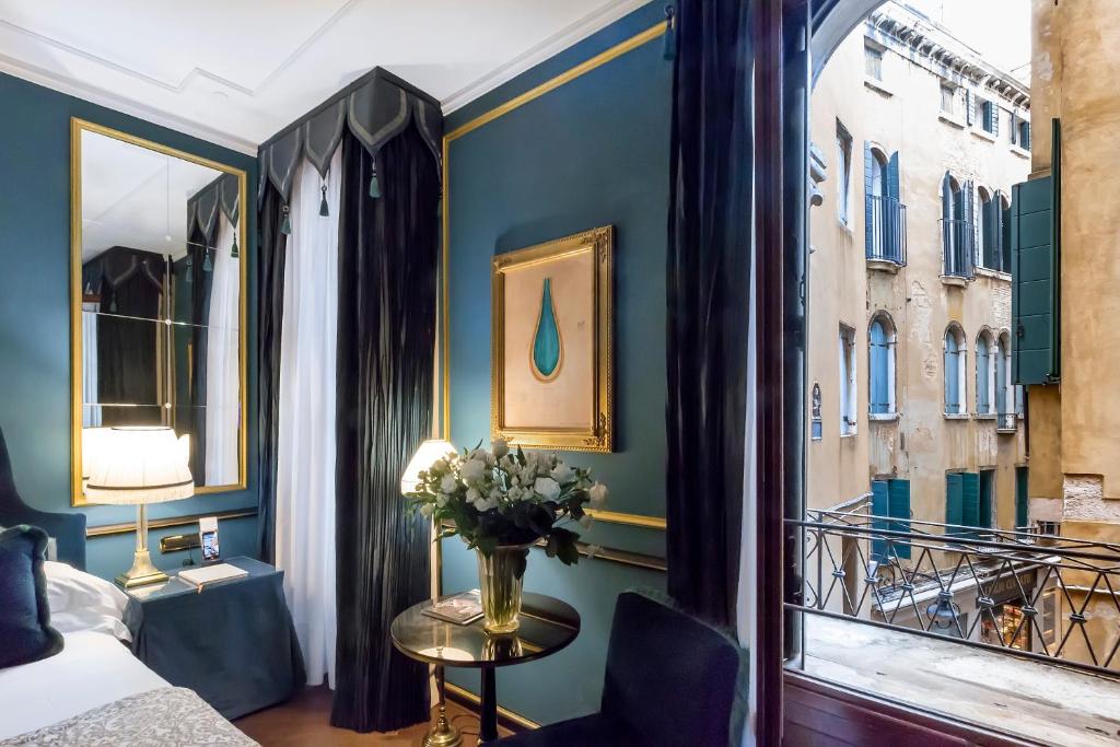 um quarto com um vaso de flores numa mesa ao lado de uma janela em Splendid Venice - Starhotels Collezione em Veneza