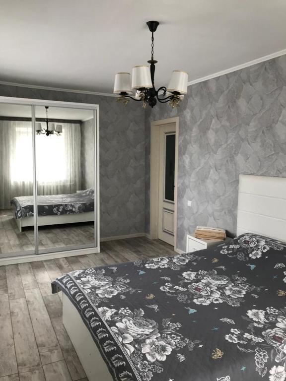 - une chambre avec un lit et un grand miroir dans l'établissement Двухкомнатная квартира рядом Парк Афганцев Телеценр Вокзал, à Pavlodar
