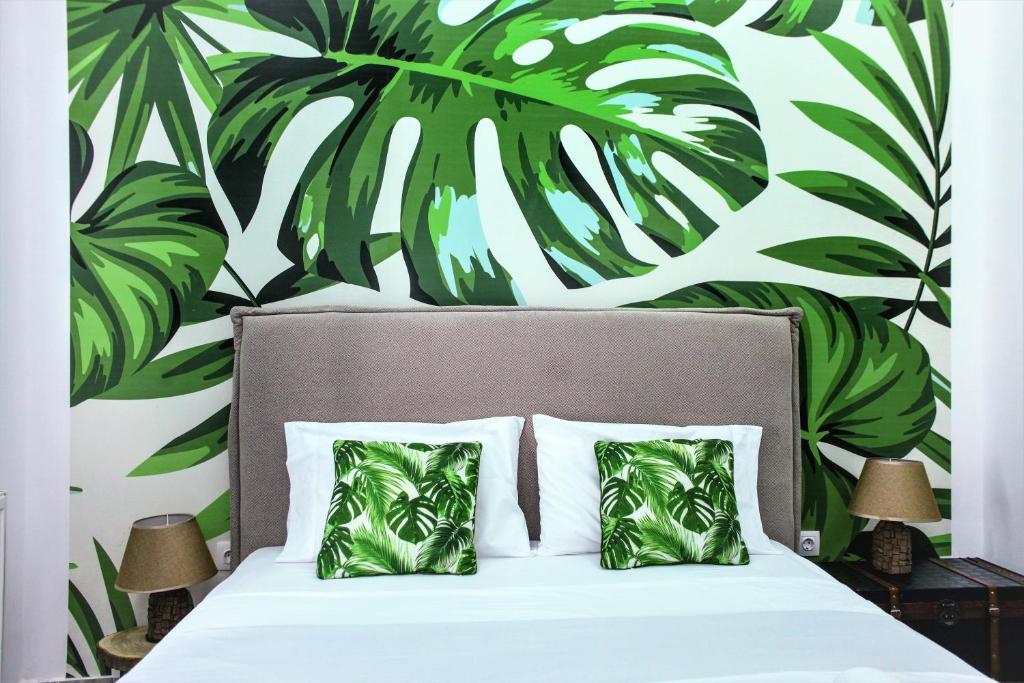 una camera da letto con un letto dipinto a parete con foglie verdi di Royal Luxury Suite ad Atene