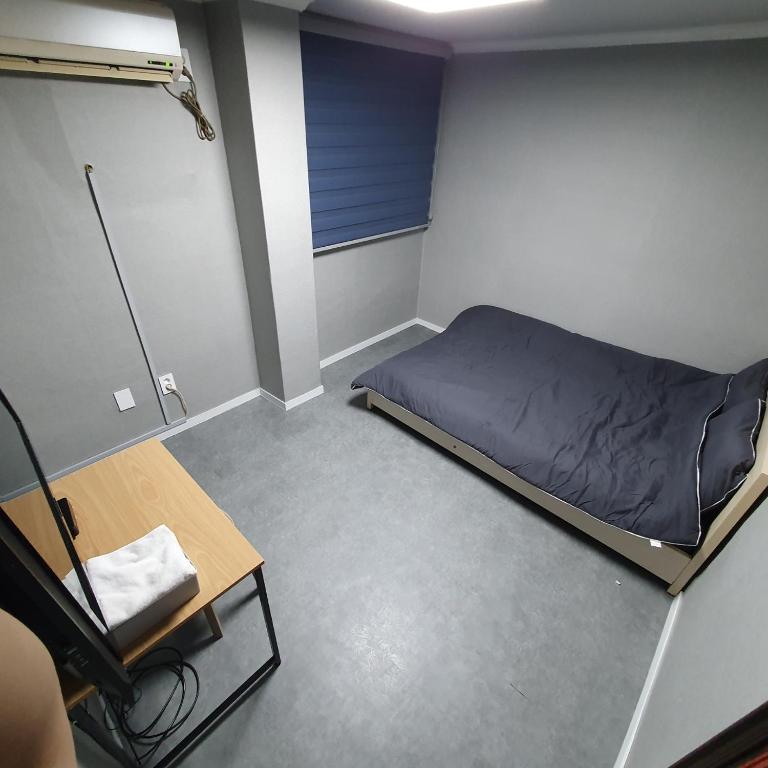 a small room with a bed and a chair at Seven Hostel in Seoul