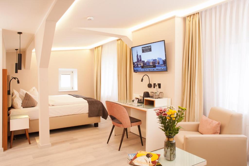 ein Hotelzimmer mit einem Bett und einem Schreibtisch in der Unterkunft Hotel Schweriner Hof in Stralsund