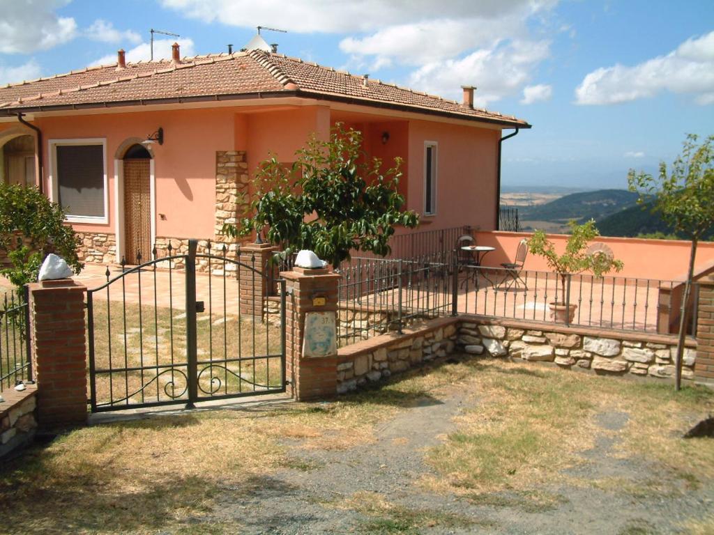 a house with a gate in front of it at Casa Papacqua in Castellina Marittima