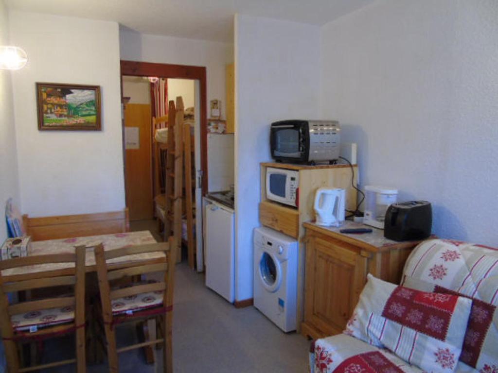 a living room with a kitchen with a microwave at Studio Valfréjus, 1 pièce, 2 personnes - FR-1-561-73 in Valfréjus