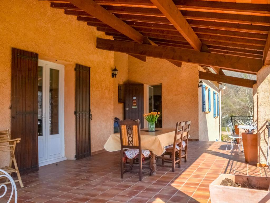 a dining room with a table and chairs on a patio at Valansolette in Beynes