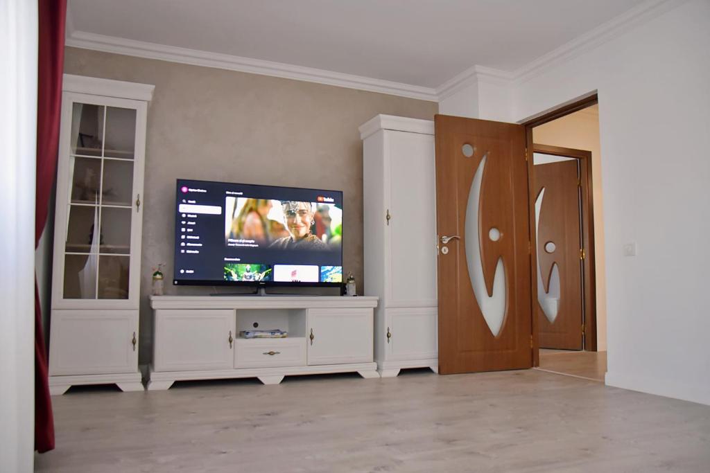 a living room with a flat screen tv on a cabinet at Apartament ILEV in Roman