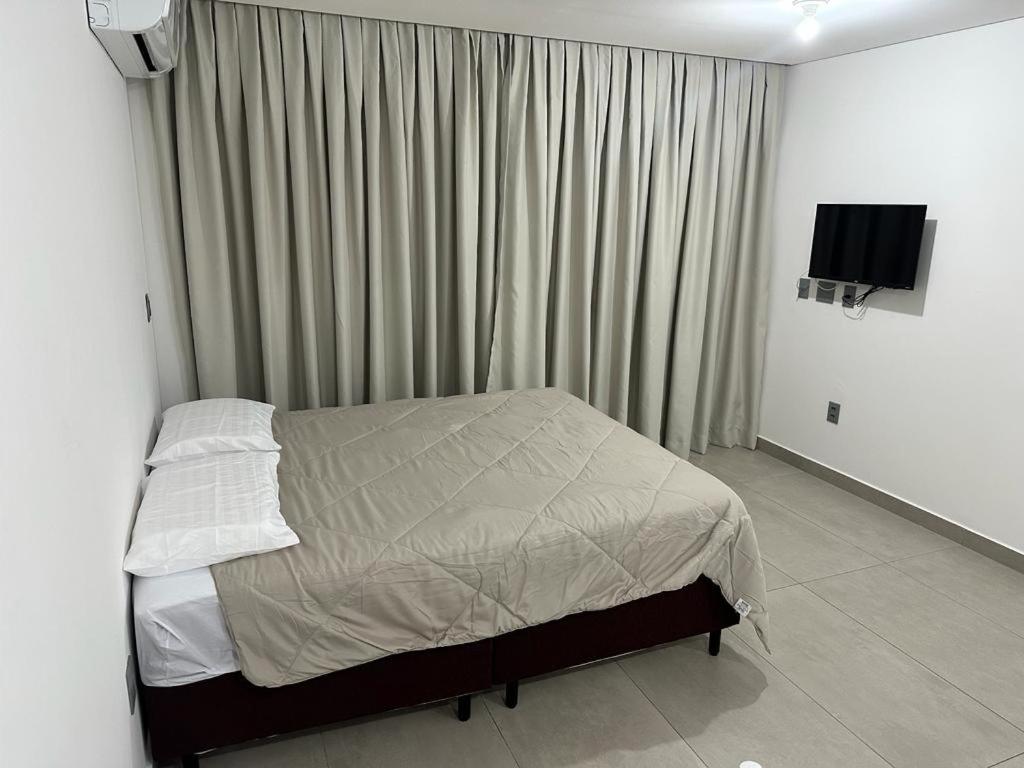 um quarto com uma cama e uma televisão em Apartamento à 100 metros da praia. em João Pessoa