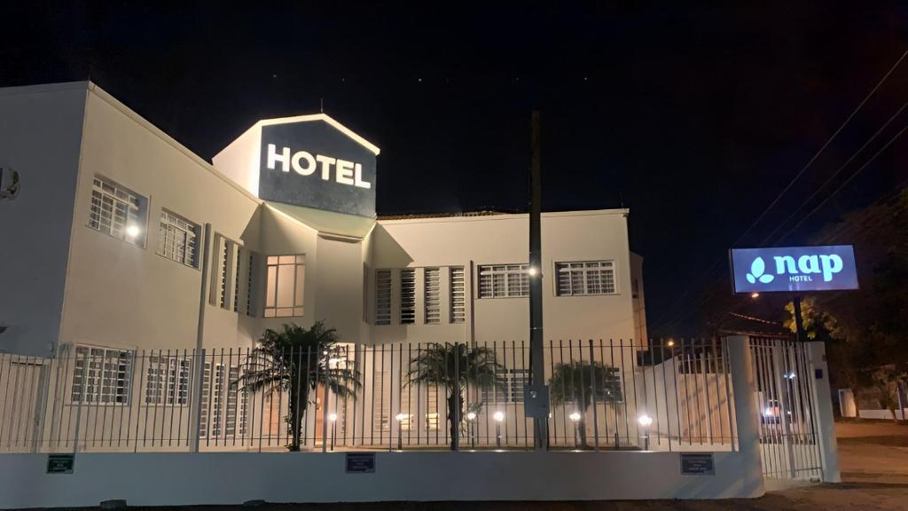 un hotel con un cartel encima de él por la noche en Nap Hotel, en Ponta Grossa