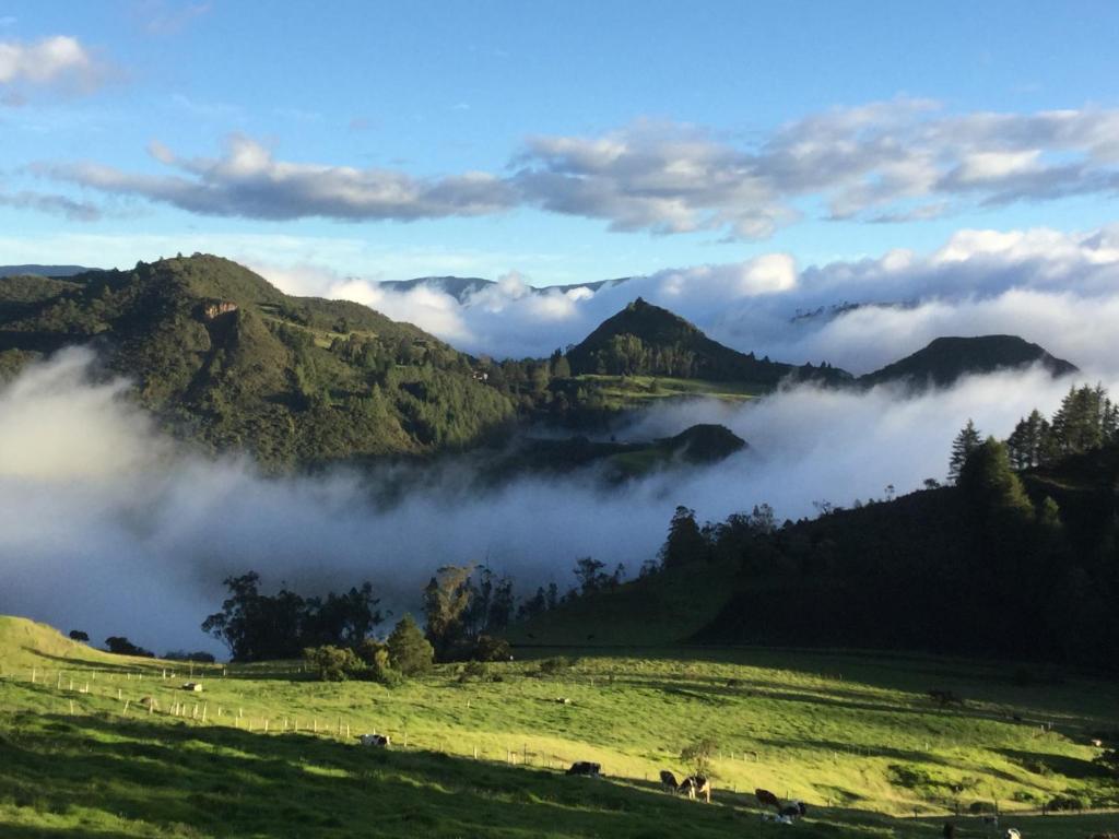 uma vista para um vale com nuvens nas montanhas em Vista Hermosa EconoSuite em Turi