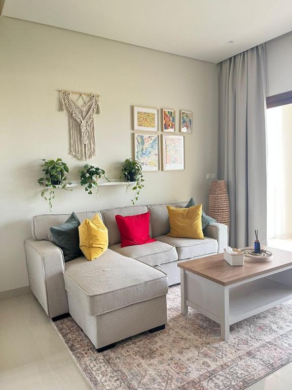 Jebel Sifah Golf View Apartment في مسقط: غرفة معيشة مع أريكة وطاولة قهوة