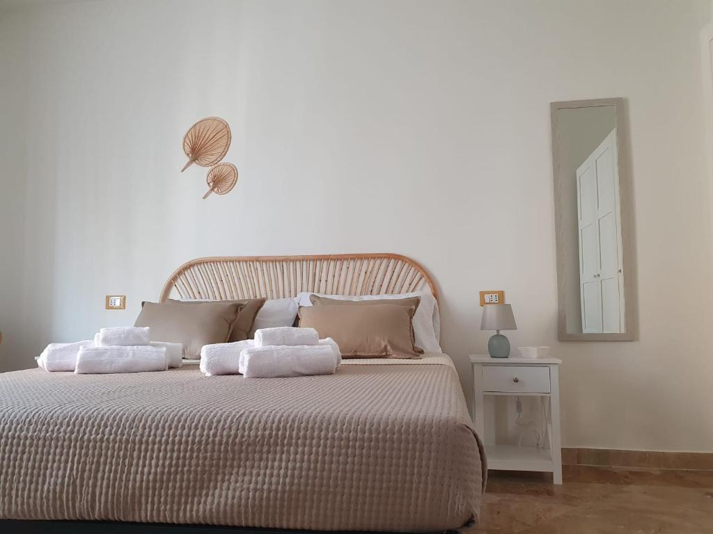 - une chambre blanche avec un lit et des serviettes dans l'établissement Posidonia B&B, à Terrasini