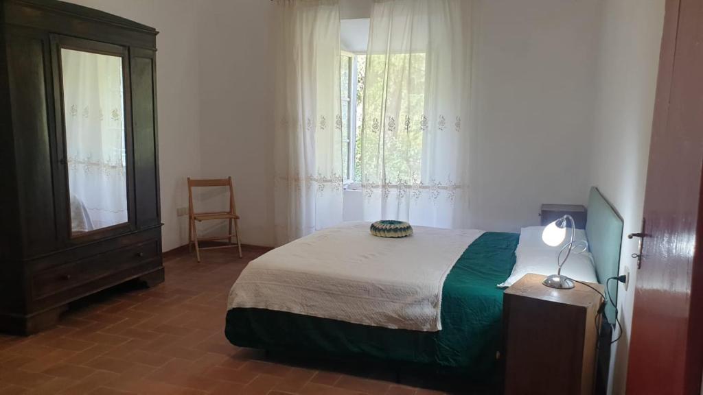 a bedroom with a bed and a dresser and two windows at La Veranda in Marradi