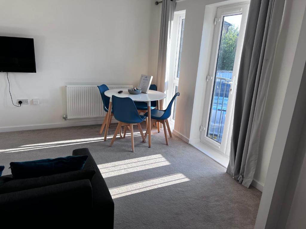 a living room with a table and chairs and a window at The Coach House in Welwyn Garden City