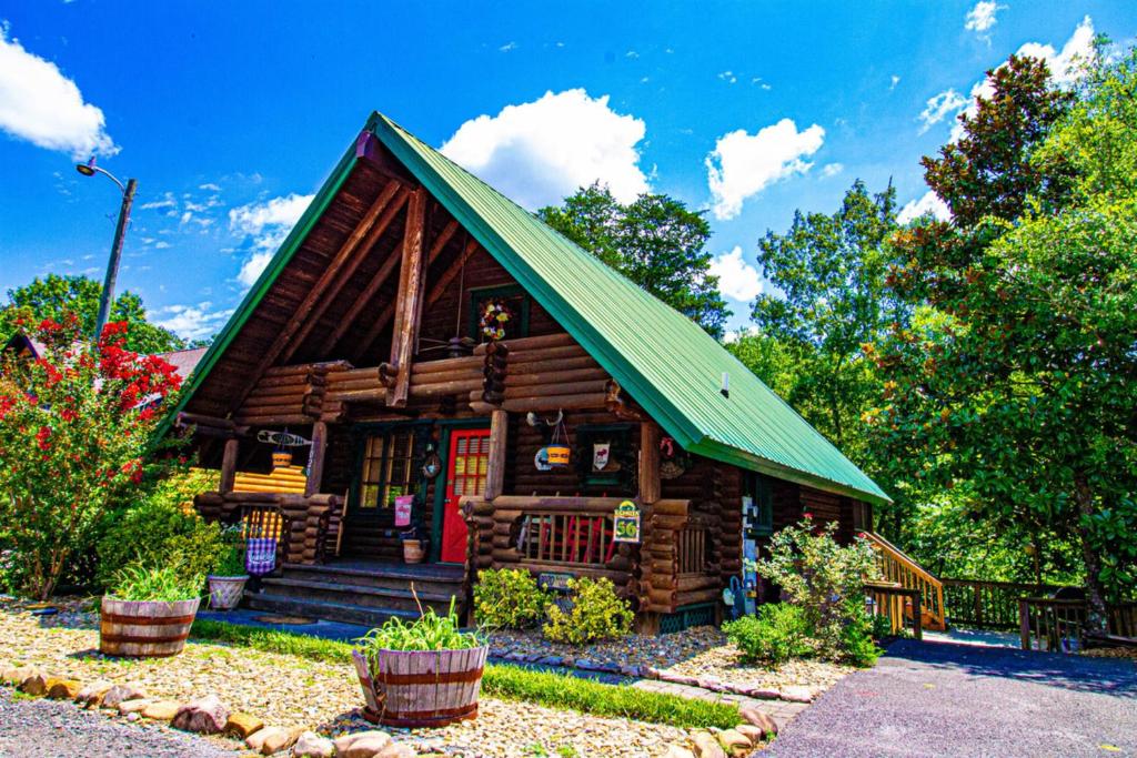 ein kleines Blockhaus mit grünem Dach in der Unterkunft Moose Lodge with Hot Tub in Sevierville