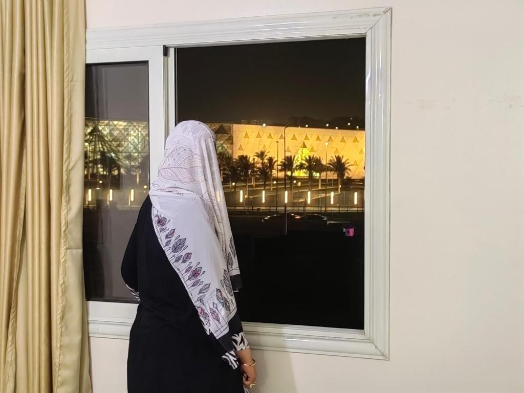 una mujer con un velo parada frente a una ventana en Adams Guest House, en El Cairo