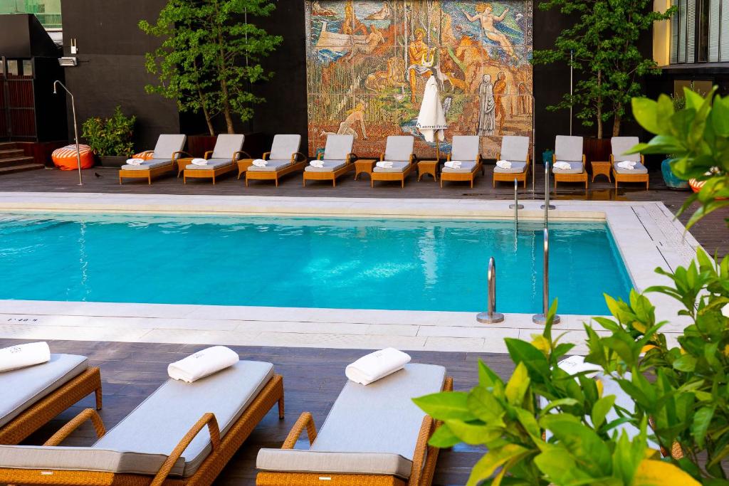 una piscina con tumbonas y una piscina en Wellington Hotel & Spa Madrid, en Madrid