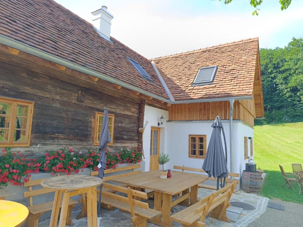 een houten patio met een houten tafel en banken bij Ferienhaus Grabenhansl in Stubenberg