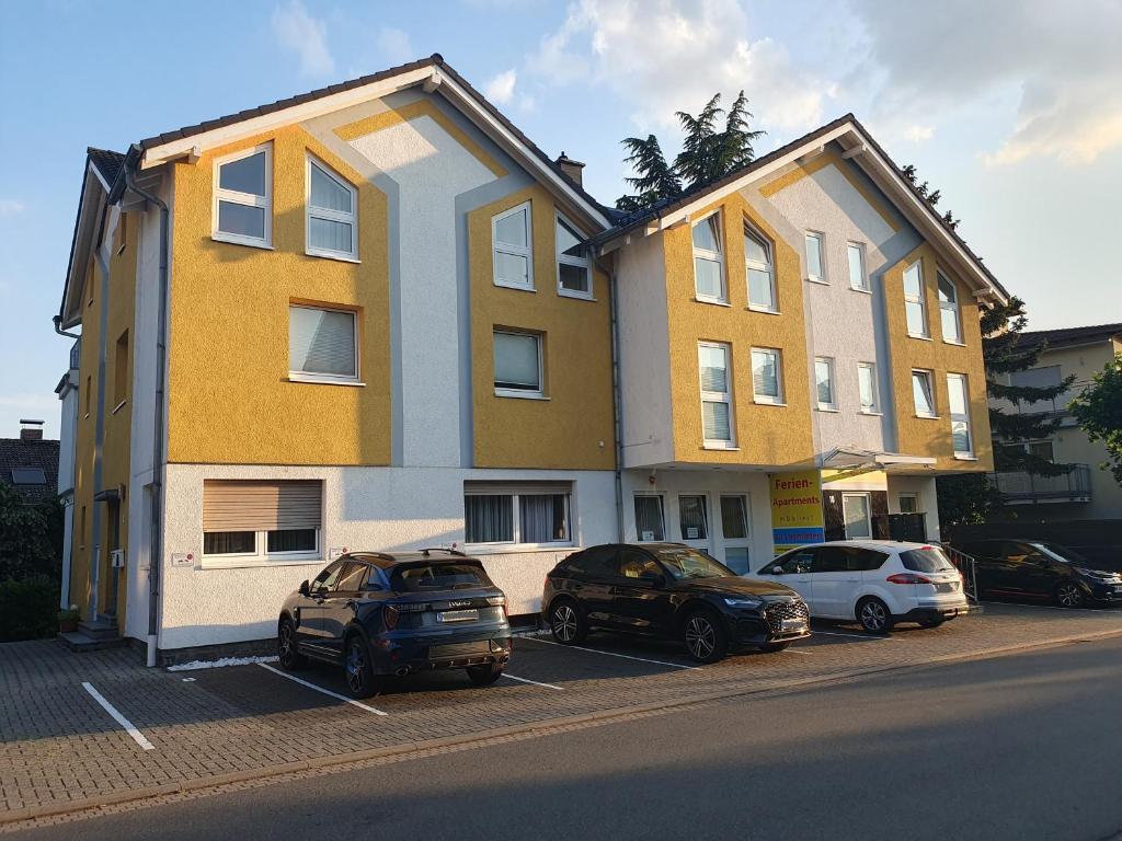 two buildings with cars parked in a parking lot at ABM Apartment Haus in Zwingenberg
