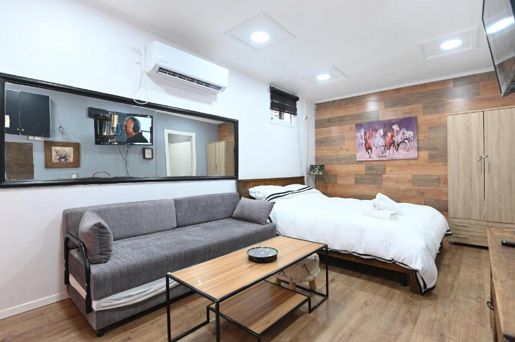 ein Wohnzimmer mit einem Sofa und einem Bett in der Unterkunft צימר הבקתה in Tiberias