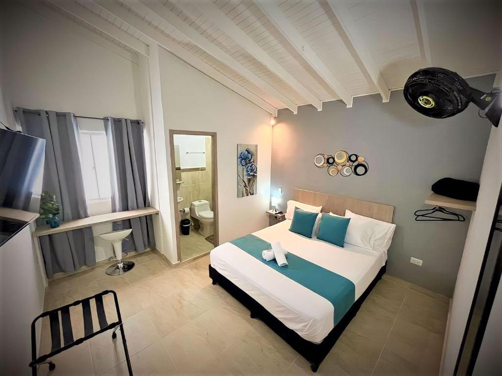 1 dormitorio con 1 cama grande con almohadas azules y blancas en Ayenda 12 Nights, en Medellín