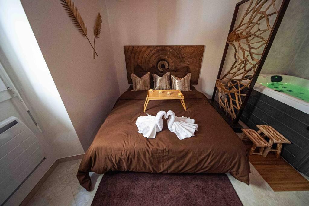 een slaapkamer met een bed met twee handdoeken erop bij L'instant en Provence -Logement de Standing avec Jaccuzi à 20min d'Avignon in Le Thor