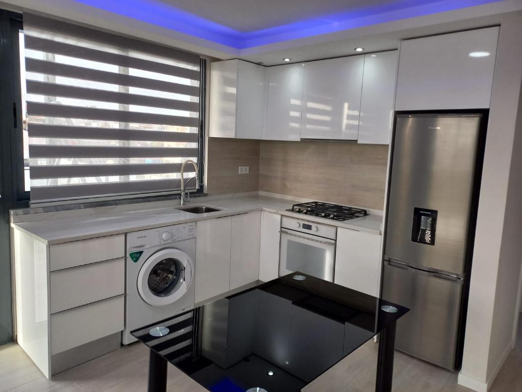 a kitchen with white cabinets and a washer and dryer at La Juanita - Residência Marina in Praia