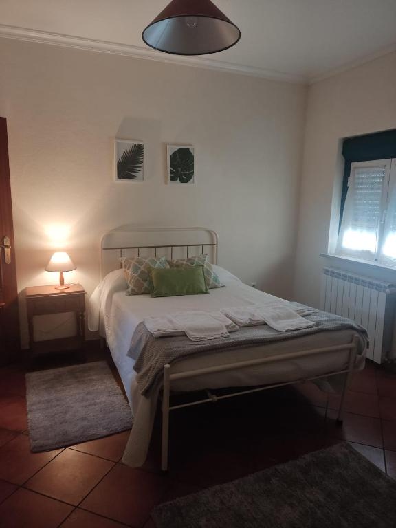 a bedroom with a bed and a lamp on a table at Casas da Estrela in Gouveia