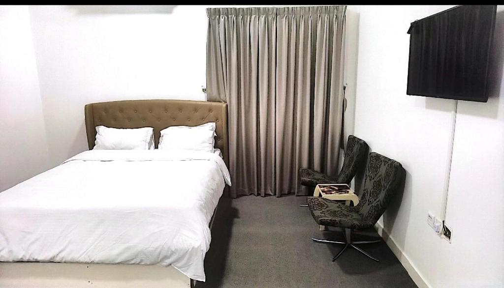 Habitación de hotel con cama y silla en شقة السلمة أم القيوين, en Umm Al Quwain