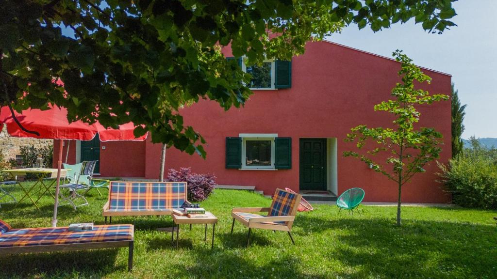 ein rotes Haus mit zwei Stühlen und einem Tisch in der Unterkunft Villa Silvana - Apt Giulia & Michela with terrace & parking in Perugia