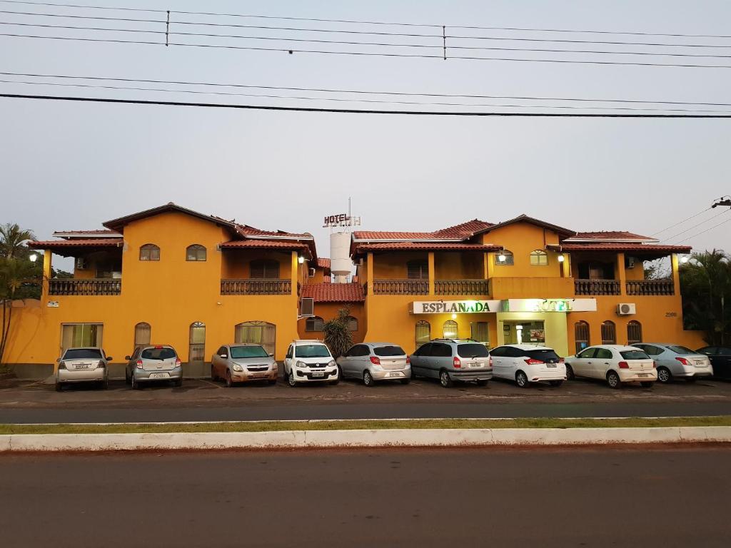 een groep auto's geparkeerd op een parkeerplaats voor een gebouw bij Esplanada Hotel in Paraguaçu Paulista