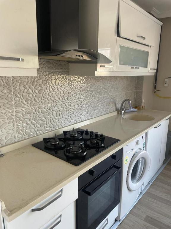 a kitchen with a stove top oven next to a sink at BMB GROUP ÇINARCIK HOME 3 in Çınarcık