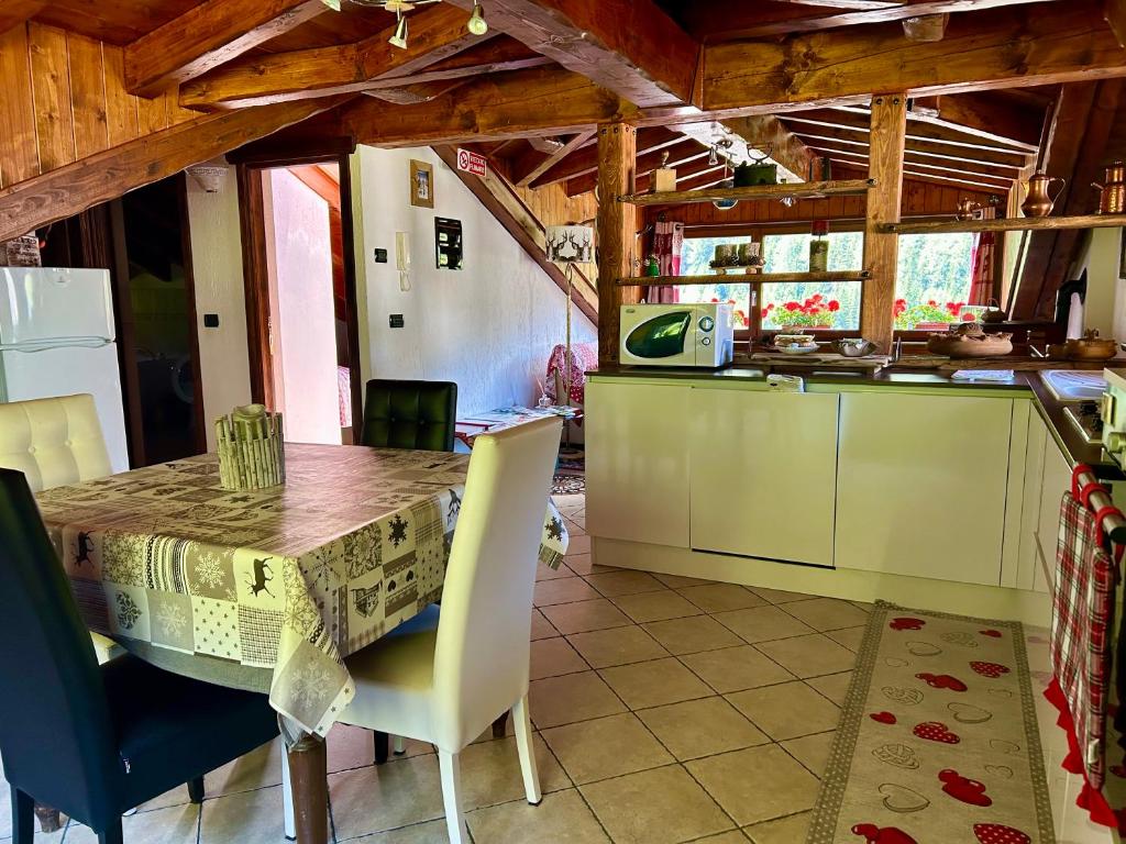拉特烏伊萊的住宿－Mansarda luminosa，一间厨房,内设一张木桌和椅子