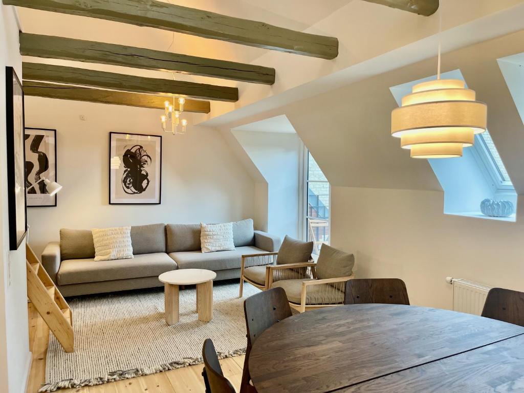 een woonkamer met een tafel en een bank bij Large 5 Bedroom Flat in Lovely Urban Area in CPH Ø in Kopenhagen