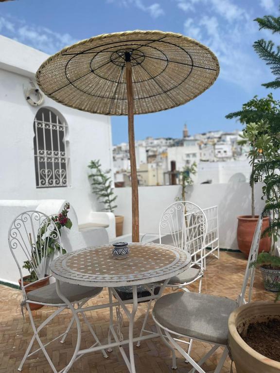 a table and chairs with an umbrella on a patio at Riad SULTANA in Tangier