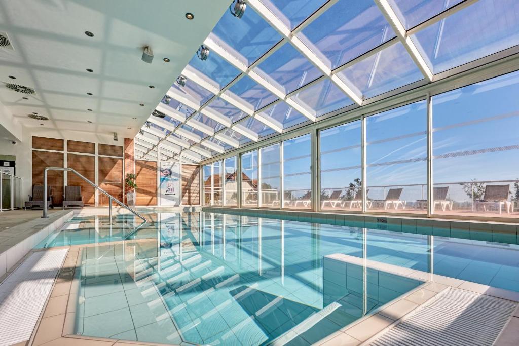 a large swimming pool with a large glass ceiling at Pierre & Vacances Premium Residence & Spa Houlgate in Houlgate
