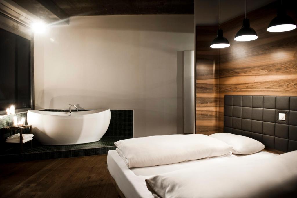 a bathroom with a tub and a bed and a sink at Hotel Daniel Vienna - Smart Lifestyle Near City Centre in Vienna