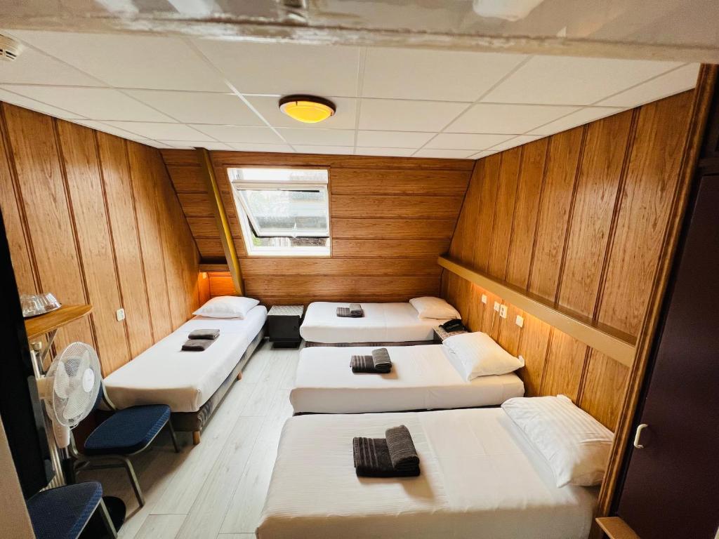 a row of beds in a room with wooden walls at Hotel Sharm in Amsterdam